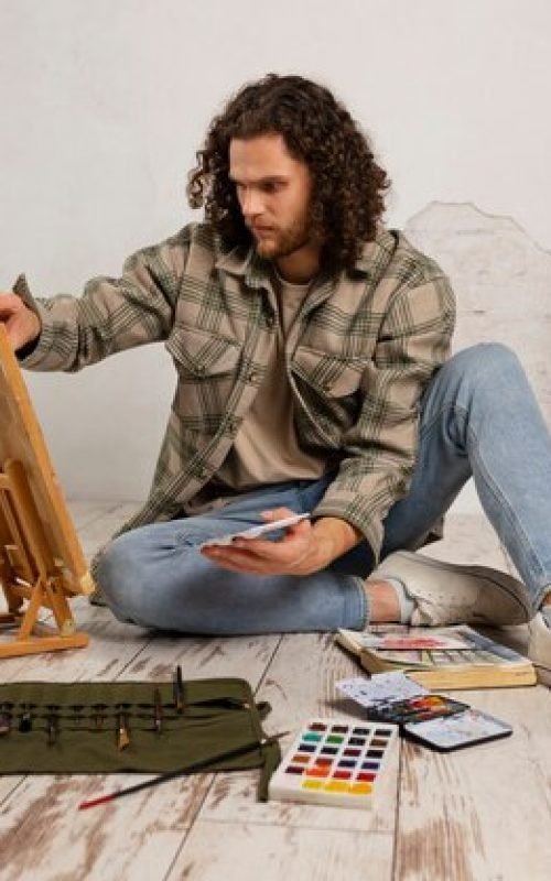 male-artist-painting-studio-with-watercolors_23-2149908464