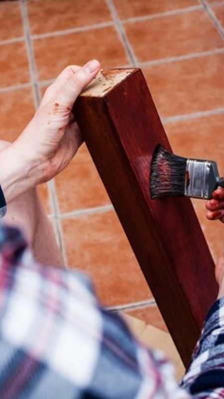 midsection-young-man-painting-wooden-plank-while-sitting-home_1048944-6416117
